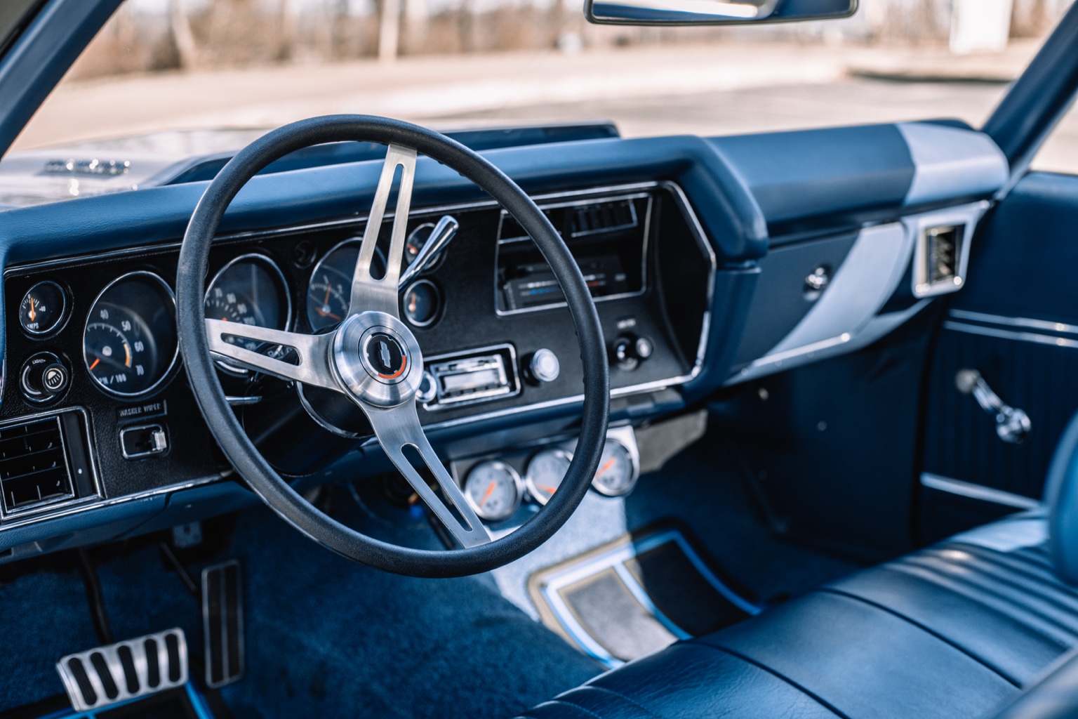 Blue classic Chevrolet interior with a three-spoke steering wheel and analog gauges