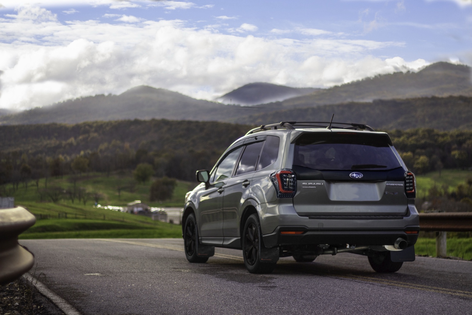 Subaru Forester on a mountain road beneath a dramatic sky